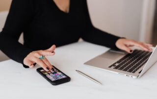 A successful entrepreneur working on her phone and computer.