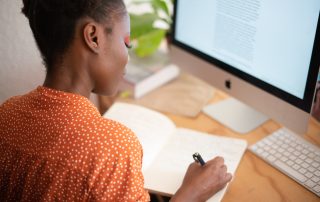 Risks of Outsourcing: Woman Writing Notes on Laptop
